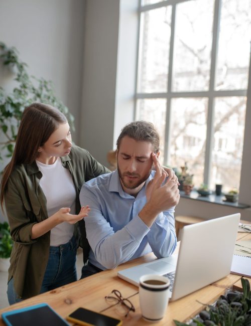 Woman helping her colleague having a headache